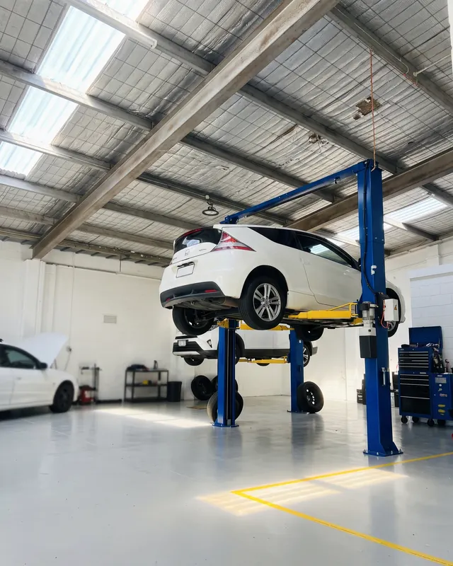 A car raised on the hoist in Slim's Garage, Frankston